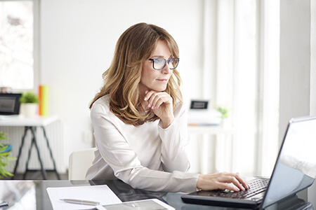 Woman in white at laptop